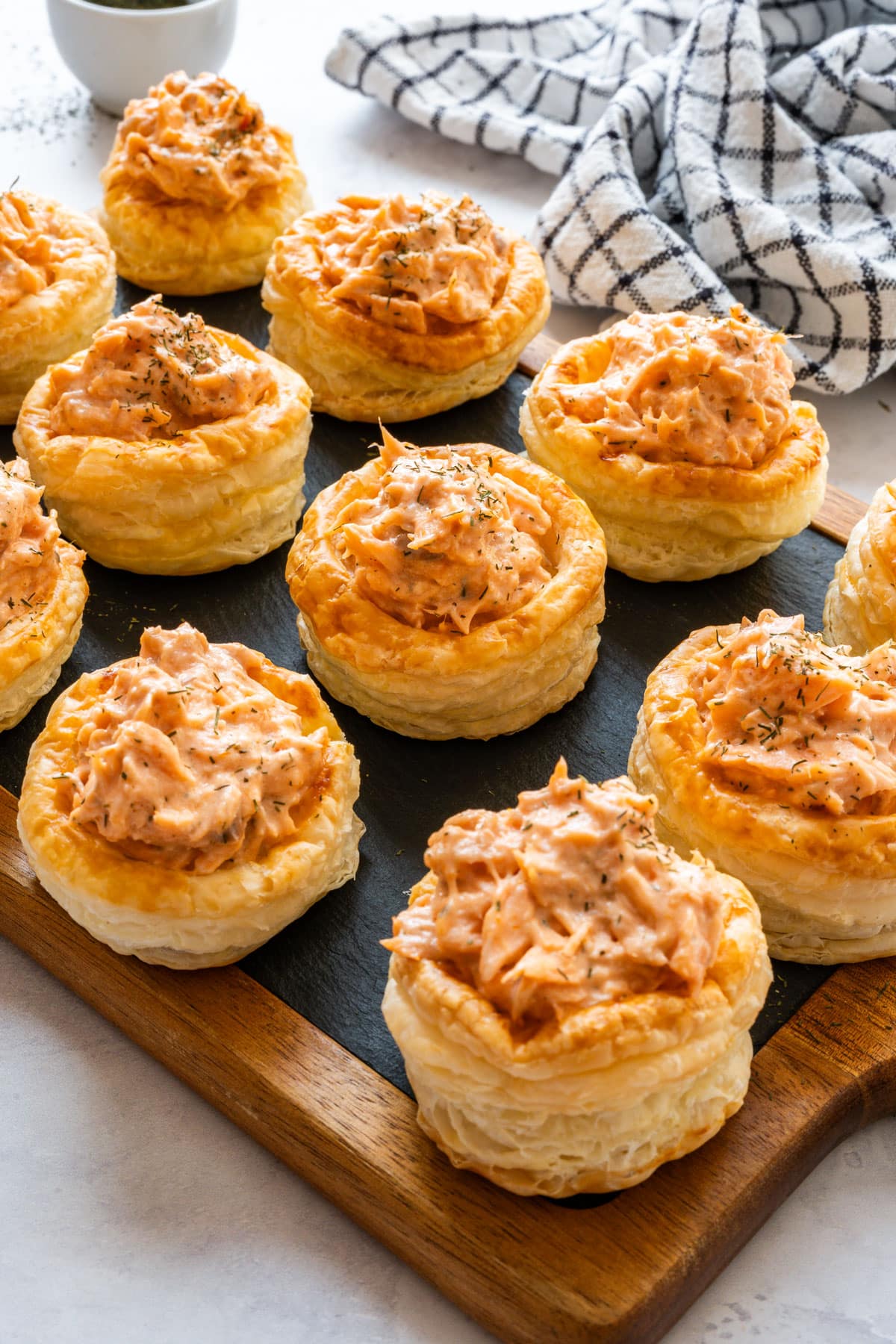 Salmon vol-au-vents with creamy salmon filling and dried dill on a slate serving board.