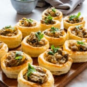 Chicken and mushroom vol-au-vents with a creamy white wine filling, served cold in bite-size puff pastry shells. Make the filling and cases a day ahead, then fill them shortly before serving. An easy make-ahead party appetizer, and rotisserie chicken works too.