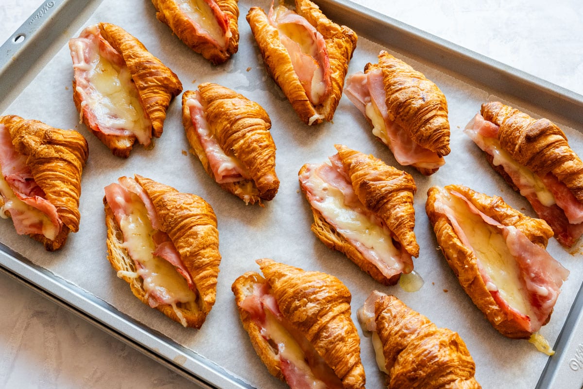 Overhead view of the baked croissants, with ham and melted cheese tucked into each one.
